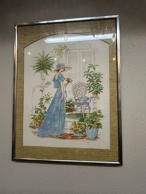 1976 print signed Coby women in a blue dress hat plants vintage wall hanging art